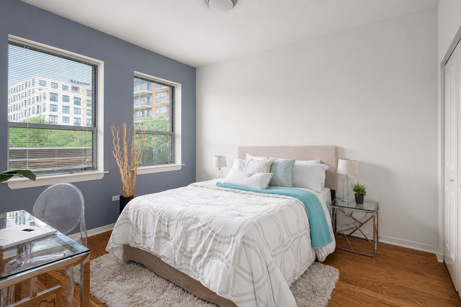A bright, freshly made bedroom with natural light streaming through windows